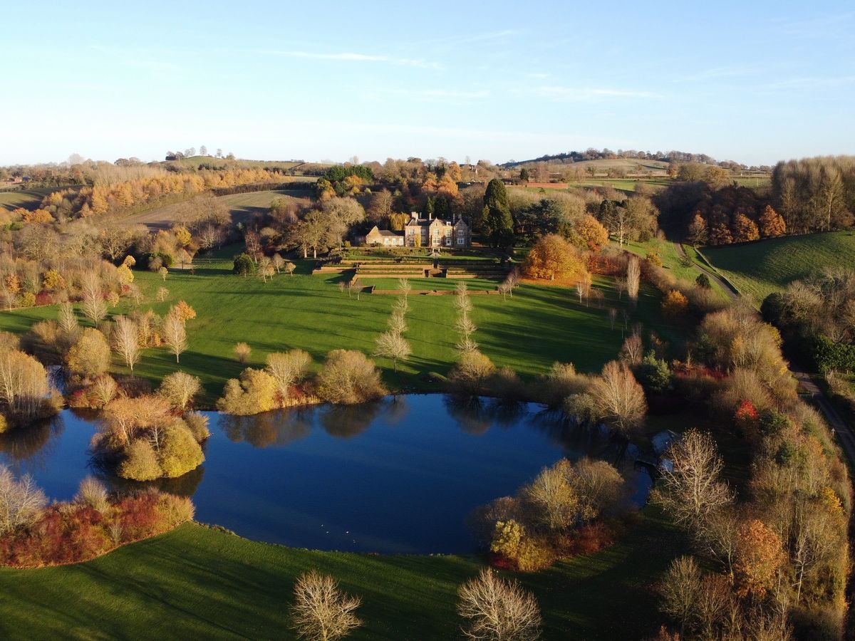Aerial view of a country manor and lake in autumn