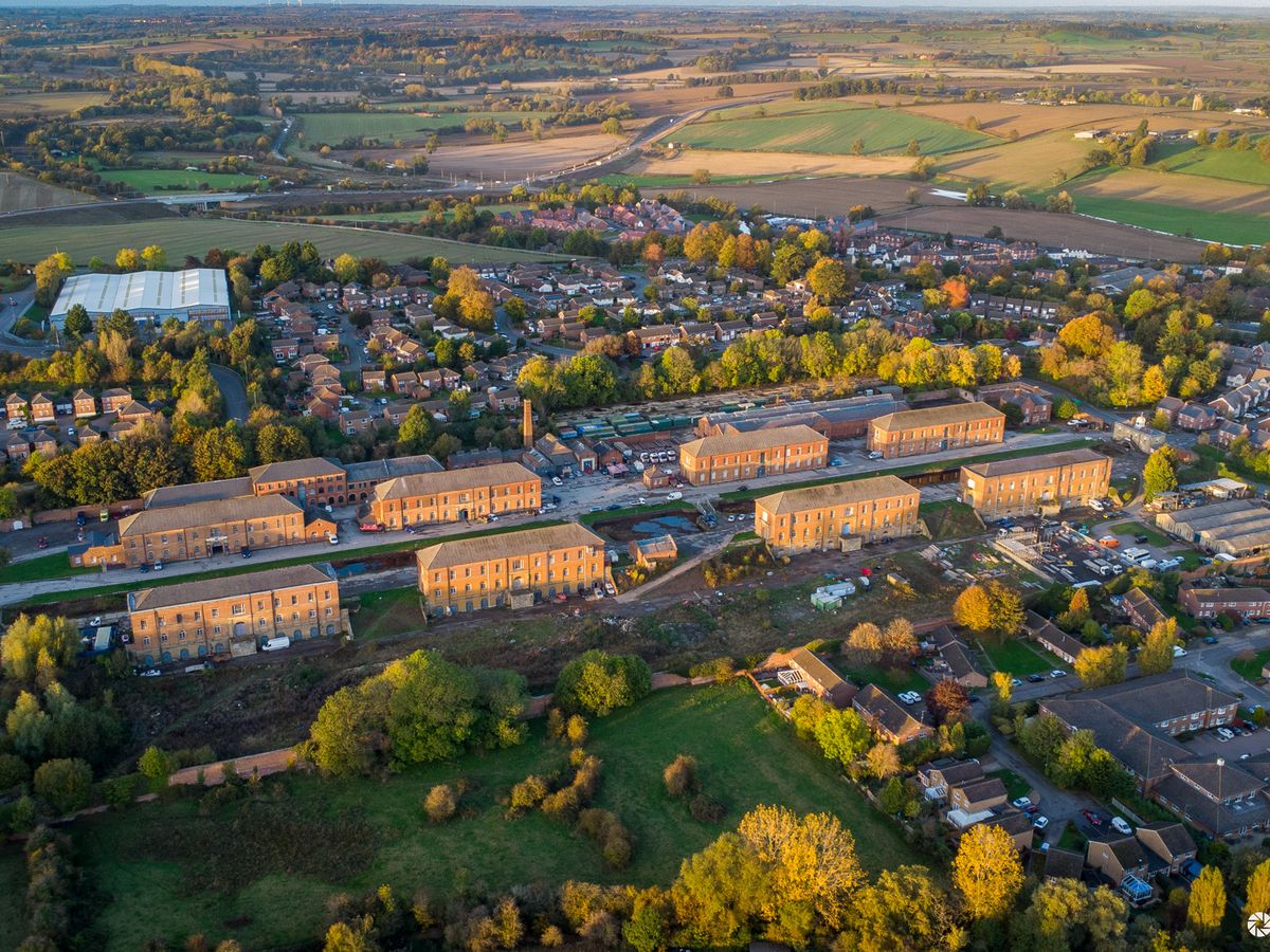 Aerial view of a row of historic red-brick storehouses