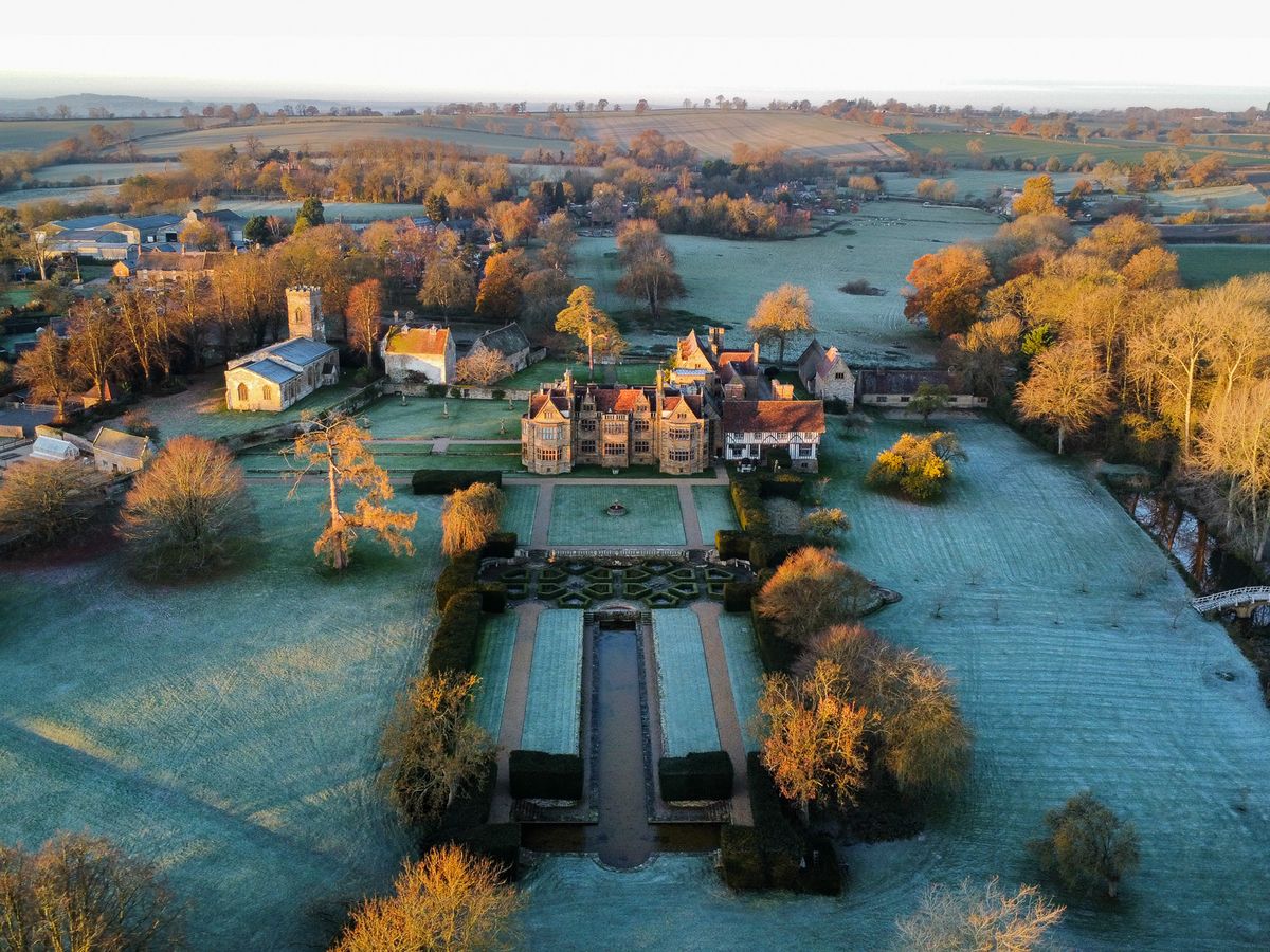 Aerial view of a historic manor house on a frosty morning