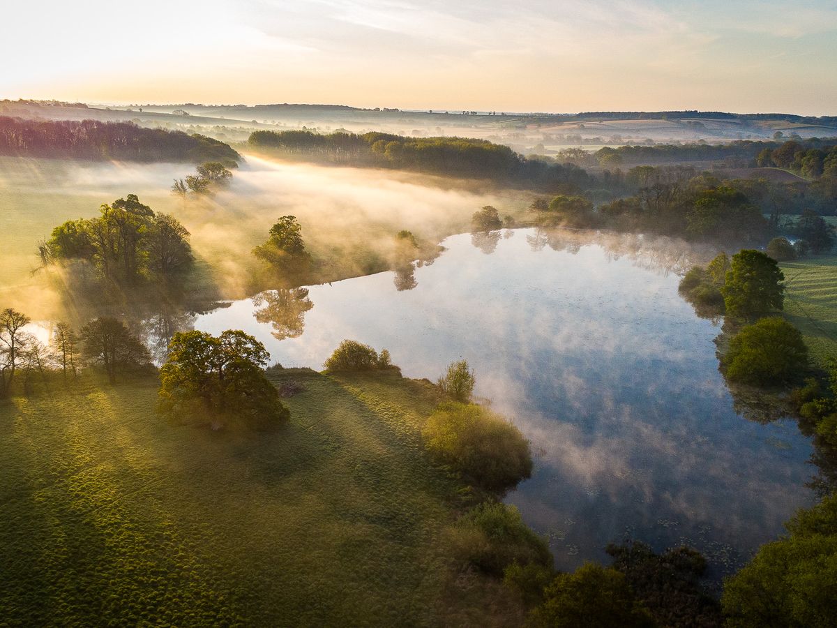 Aerial view of a misty lake at sunrise
